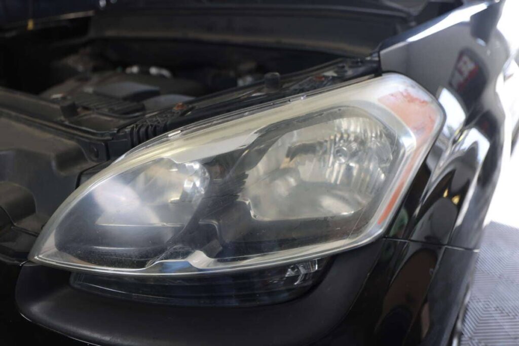 A close-up view of a cloudy headlight on a vehicle.